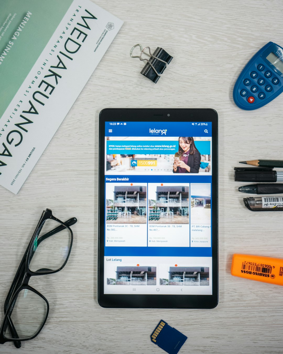 a-tablet-computer-sitting-on-top-of-a-desk-next-to-a-calculator-gzzvgpinhhw